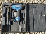une cloueuse pneumatique bleue et noire dans un coffret noir