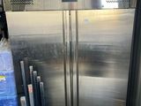 a large stainless steel refrigerator in the middle of a pile of boxes