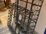 a black iron shelf with a mirror on top of it