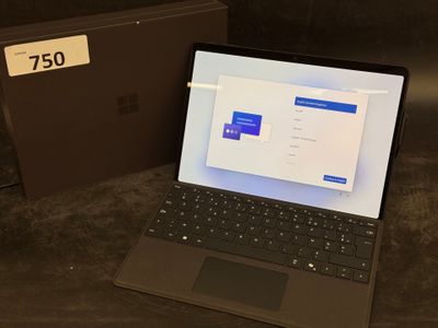 a laptop computer sitting on a table next to a box