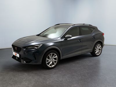 Une voiture grise est garée dans une pièce aux murs blancs.