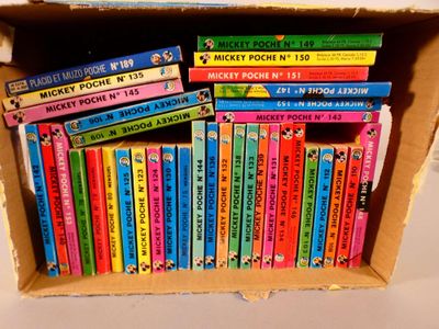 many books in a box that are stacked on top of each other