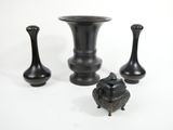three black vases sitting next to each other on a white surface