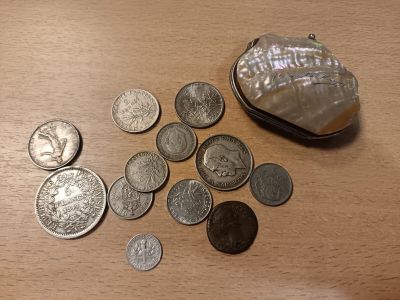 un coquillage et quelques pièces de monnaie posés sur une table