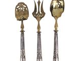 three silver spoons and a spoon with a flower on them
