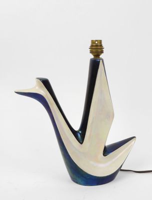 une lampe en forme d'oiseau, bleue et blanche, posée sur une table
