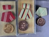 three medals are in a display case with ribbons and ribbons
