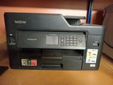 the printer is sitting on top of the desk next to the printer