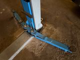 a fork lifter sitting on the ground next to a pole
