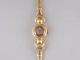 an image of a gold wrist watch with a brown face
