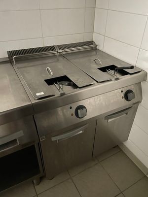 une plaque de cuisson en acier inoxydable dans une cuisine au sol carrelé