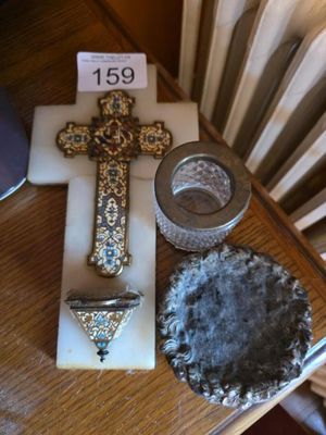 a cross, a candle holder, and a bowl on a table