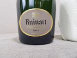 a bottle of champagne next to a roll of toilet paper
