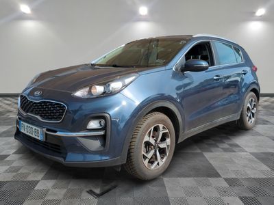 une voiture bleue est garée dans une pièce au sol à carreaux