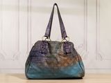 a close up of a handbag on a table with a wall in the background