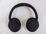 a close up of a pair of black headphones on a white surface
