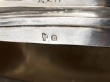 a close up of a silver plate with a bird on it