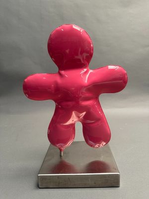 a pink sculpture of a man on a metal base