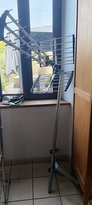 un étendoir à linge dans un coin d'une pièce avec une fenêtre