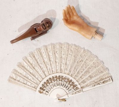 un éventail en bois et une main en plastique munie d'un manche en bois