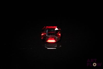 un gros plan d'une pierre rouge sur une surface noire