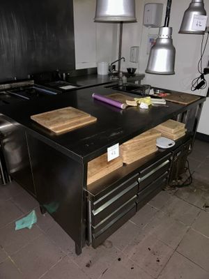 a kitchen with a black counter top and a wooden bench