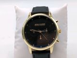 a black and gold watch sitting on a white pillow