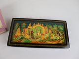 a small box with a painting on it next to a small box with a picture on it