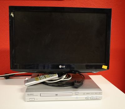 un téléviseur à écran plat posé sur un lecteur DVD