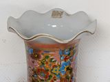 a vase with a floral design on it sitting on a table