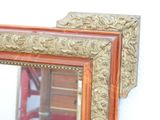 a mirror with a gold frame on the wall