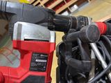 a red and black corded drill and a black and white cord