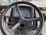 a steering wheel and dashboard of a tractor on the road