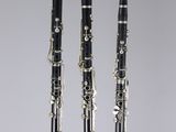 trois clarinettes sont alignées sur une surface blanche