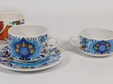 three cups and saucers with designs on them