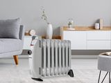 un radiateur blanc posé sur un tapis, à côté d'un canapé