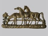 une sculpture en bronze représentant trois chevaux et un homme à cheval