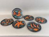 six black and orange sea life magnets sitting on top of a white surface