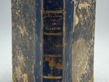 un vieux livre posé sur une surface blanche