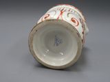 une tasse blanche décorée, posée sur une table