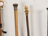 several different types of canes are lined up against a white wall
