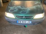 une voiture garée dans un garage où il y a plein de choses par terre
