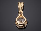 a close up of a gold and diamond pendant on a black surface