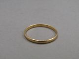 a close up of a gold wedding ring on a table