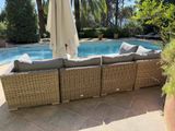 a couch that is next to a pool with umbrellas