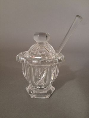 un bocal en verre contenant une cuillère, posé sur une table