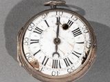 une montre de poche en argent avec des chiffres romains sur le cadran