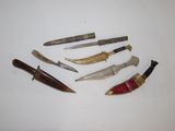 five different types of knives on a white surface