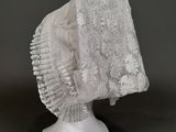sculpture blanche représentant une tête surmontée d'un voile