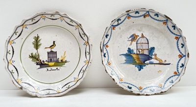 deux assiettes avec des oiseaux et une cage à oiseaux